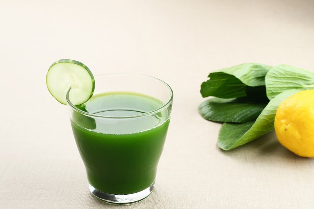 Imagem mostra copo de suco verde com couve, uma bebida refrescante e muito nutritiva.