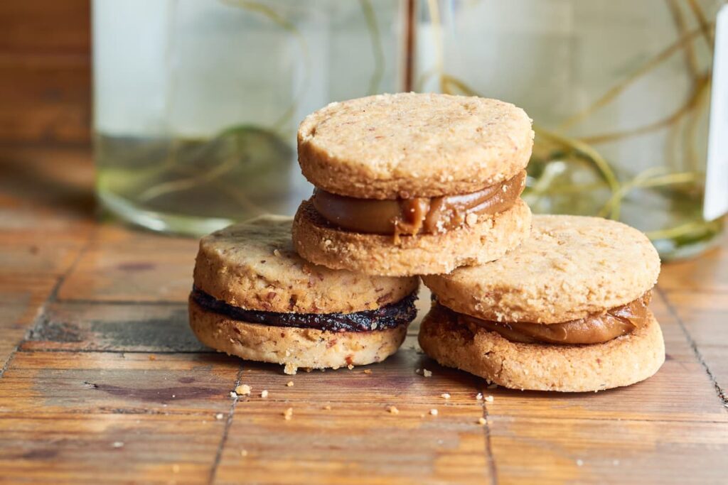 Imagem mostra alfajor com doce de leite e alfajor de chocolate.