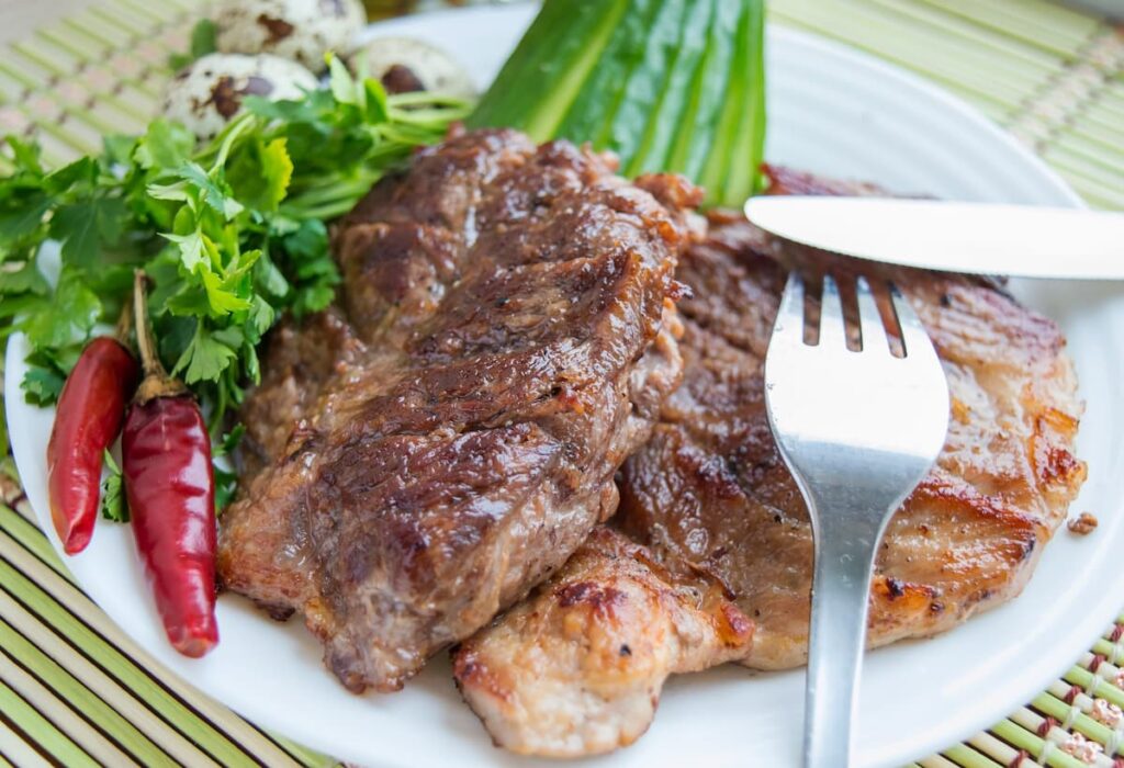 Imagem mostra bife de porco grelhado, uma das comidas com a letra d.