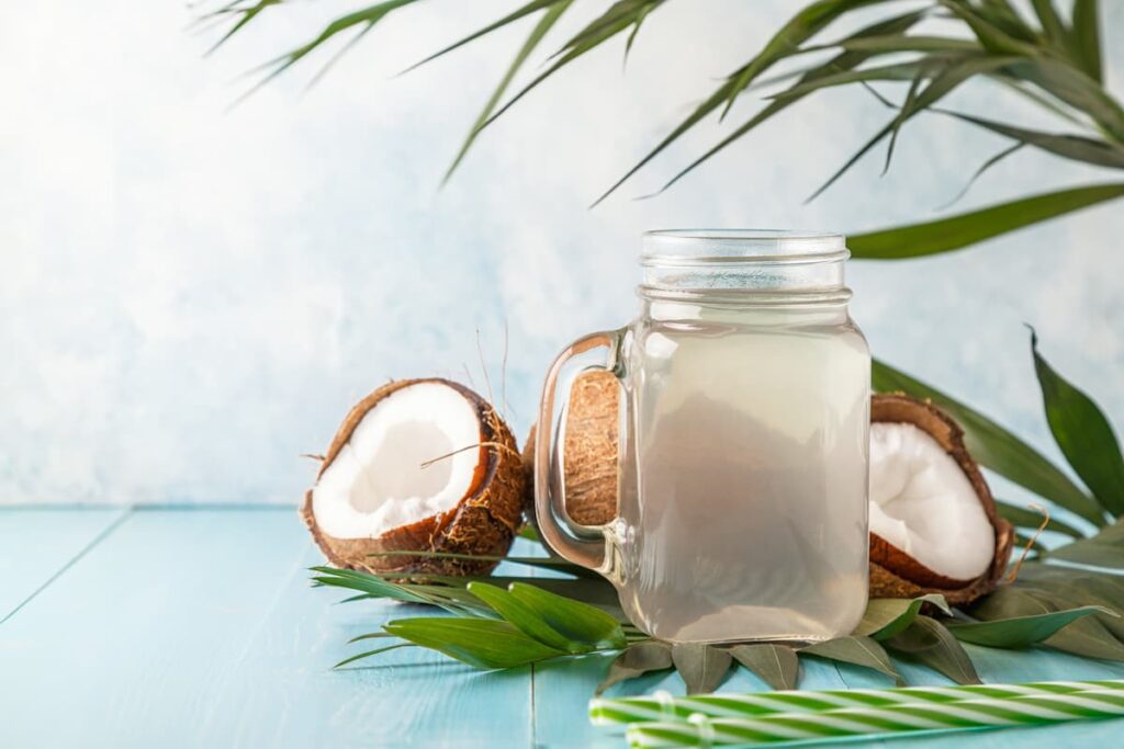 Imagem mostra uma jarra repleta de água de coco.