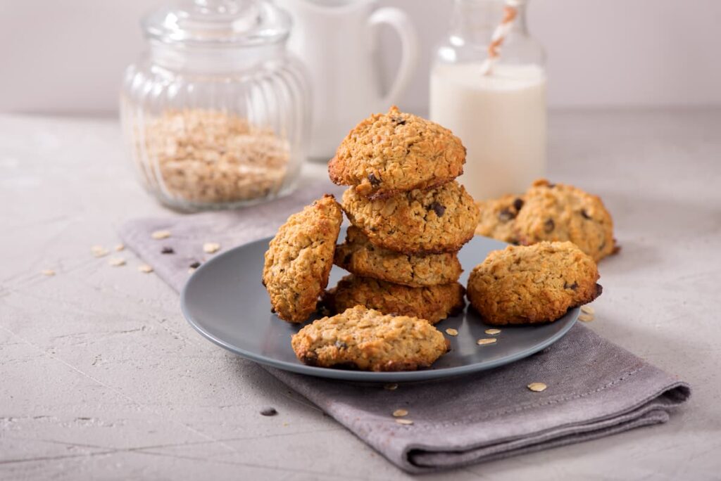 Imagem mostra cookies de aveia com mel e uva-passa, uma das receitas de snacks saudáveis com aveia para dar mais energia no dia a dia.