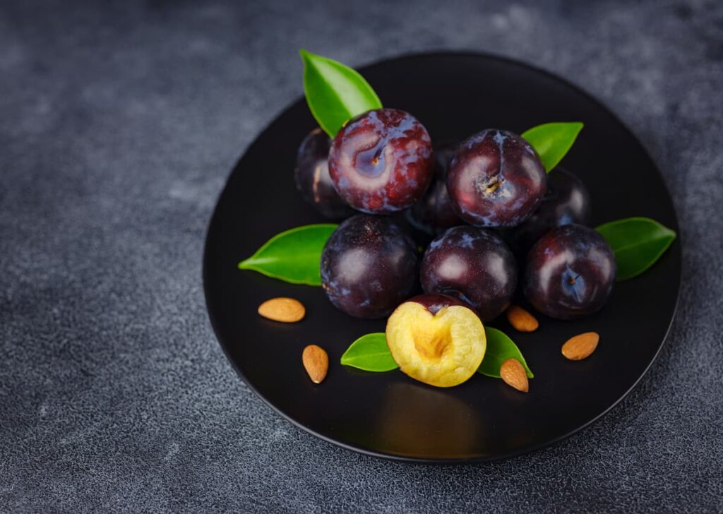 Imagem fruteira com ameixas, uma das frutas com menos açúcar para incluir na dieta.