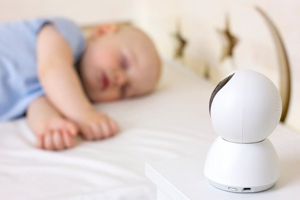Imagem mostra criança sendo monitorada por uma babá eletônica enquanto dorme.