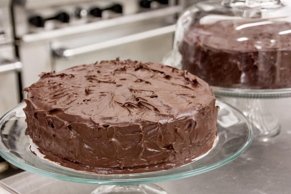 Imagem mostra um irresistível bolo de cenoura com cobertura de chocolate.