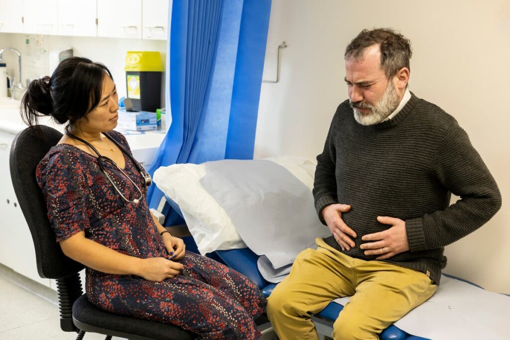 Imagem mostra médica avaliando paciente.