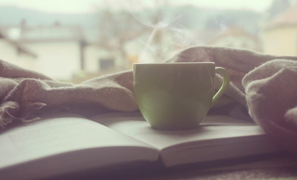 Imagem mostra xícara de café sobre um livro.